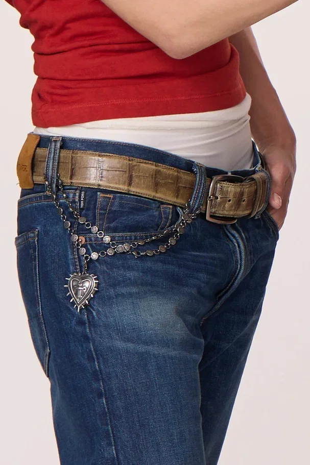 Necklace chain draped from a belt over jeans