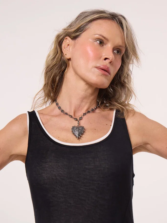 Blonde model wearing the necklace over a black top