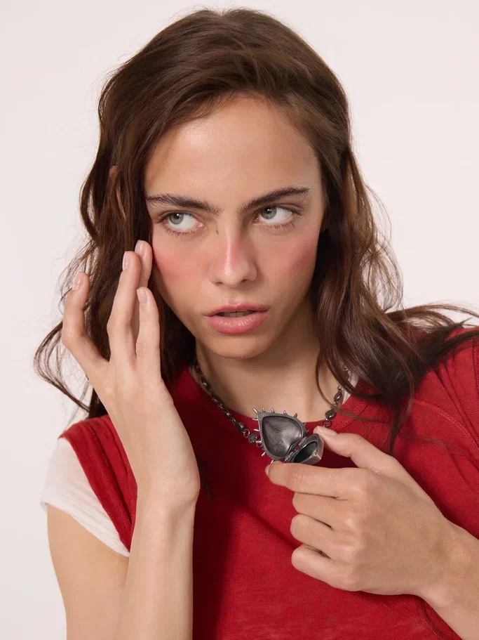 Model in a red top holding the pendant